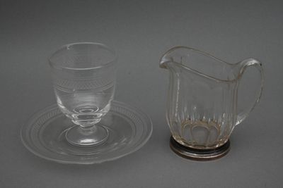 une tasse et une soucoupe en verre posées l'une à côté de l'autre sur une table