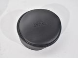 an empty black leather box on a white surface