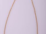 a gold chain necklace with a heart pendant on a white background