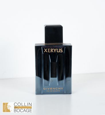 le flacon de parfum est posé sur une surface blanche
