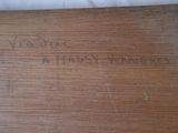 an old wooden table with writing on it and a white table cloth