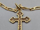 Gros plan sur un collier en or orné d'une croix