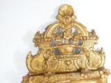 a gold clock that is sitting on a shelf