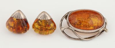 une photo représentant une paire de boucles d'oreilles et une bague ornée d'une grosse pierre d'ambre