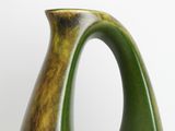 a green vase sitting on a table with a white background