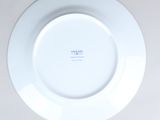 a white plate with blue writing on it on a table