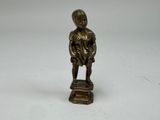 figurine en bronze représentant un garçon coiffé d'un chapeau, posée sur un socle