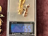 a gold nugget on a scale next to a gold nugget