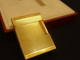 a gold cigarette case sitting on a table next to a box