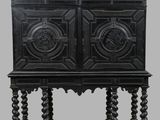 une armoire en bois noir à deux portes, surmontée d'une étagère