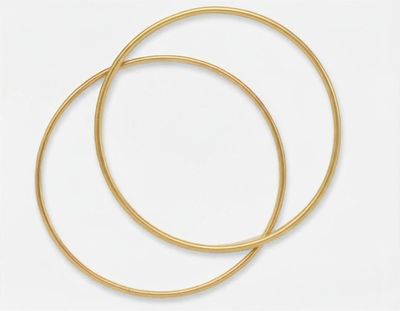 une paire de boucles d'oreilles en or sur fond blanc