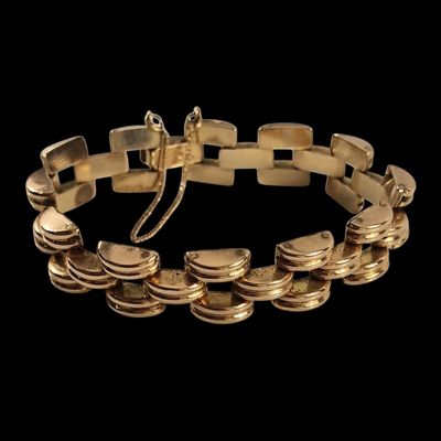 gros plan d'un bracelet en or sur fond noir