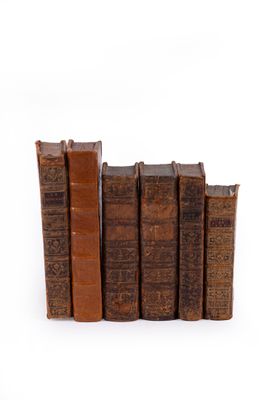 plusieurs vieux livres sont empilés sur une surface blanche