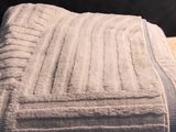 towel folded on a wooden table in front of a black wall