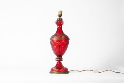 une photo d'une lampe de table en verre rouge avec un pied doré