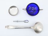 a blue glass bowl, spoon, and spoon rest on a white surface