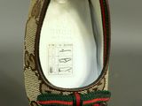 a close up of a pair of shoes with a red and green ribbon