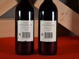 two bottles of wine sitting next to each other on a table