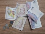 une liasse de billets posée sur une table en bois