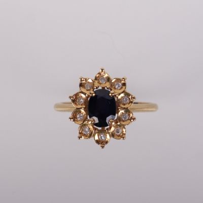une bague en or sertie d'une pierre noire entourée de diamants blancs