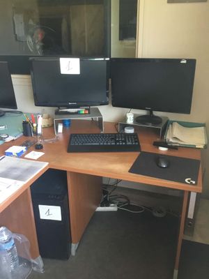 un bureau sur lequel sont posés deux écrans d'ordinateur et un clavier