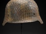 a close up of a helmet on a stand against a black background
