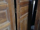 a toilet in the corner of a room next to a wooden door