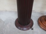 a vase that is sitting on the floor next to a wooden base