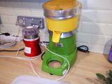 a green and yellow juicer sitting on a kitchen counter