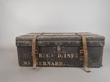 an old trunk is sitting on a table with a sign on it