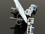 silver plated airplane brooch with blue crystals on a black surface