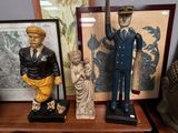 trois figurines posées sur une étagère à côté d'un tableau