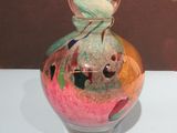 un vase en verre orné d'un motif coloré, posé sur une table