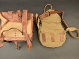 pair of leather and canvas backpacks with straps on a table