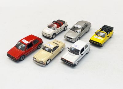 plusieurs petites voitures sont alignées sur une surface blanche