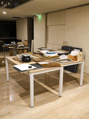 a room with a table, chairs, and a laptop on it