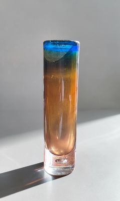 a blue and orange drink in a tall glass on a table