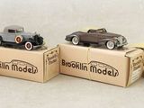 four toy cars are sitting on top of boxes on a white surface