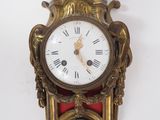 une horloge accrochée au mur, surmontée d'une couronne