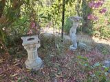 deux statues assises dans l'herbe près d'un arbre