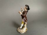 a figurine of a man in a brown coat and yellow pants