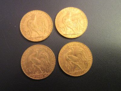 four different types of gold coins on a black surface