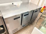 stainless steel counter top in a commercial kitchen with a glass door