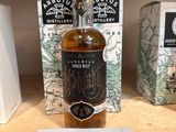 des bouteilles d'alcool sur une étagère dans un magasin, avec une étiquette de prix
