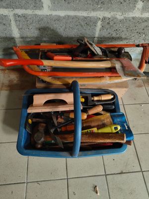 une boîte bleue contenant des outils, posée par terre près d'un mur de briques