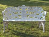 a white bench sitting in the middle of a grassy field