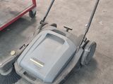 deux tondeuses à gazon posées par terre dans un garage
