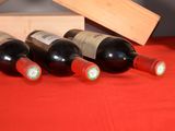 several bottles of wine are lined up on a red table cloth