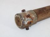an old wooden pipe with rust on it on a white surface