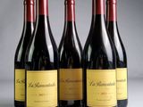 trois bouteilles de vin rouge sont alignées sur une table